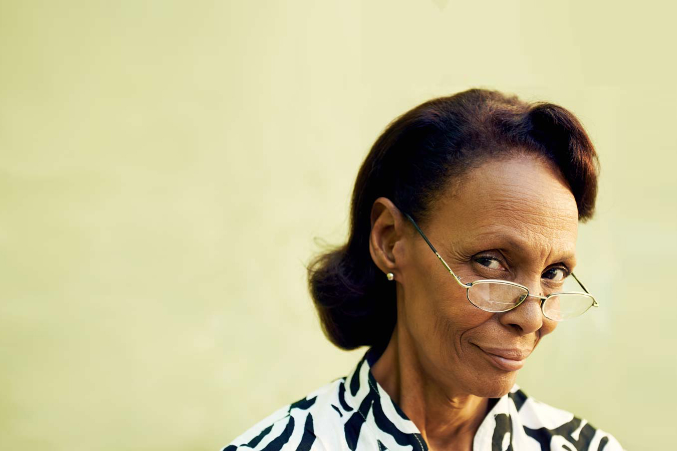 Portrait of confident old black lady with eyeglasses smiling